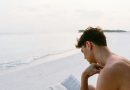 Homem lendo livro na praia