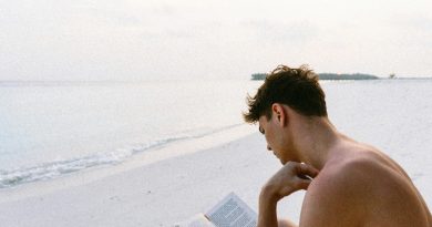 Homem lendo livro na praia