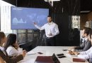 Homem apresentando slides produzidos com IA em uma reunião de trabalho