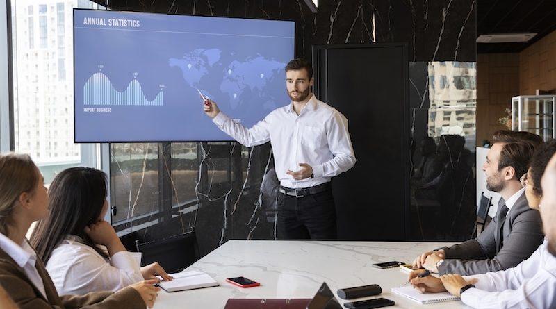 Homem apresentando slides produzidos com IA em uma reunião de trabalho