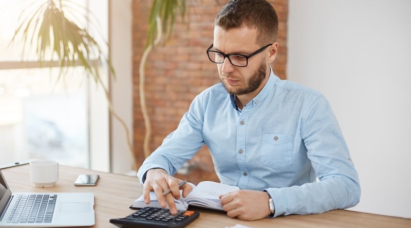 Inflação: como proteger o seu patrimônio? 1 Homem usando calculadora