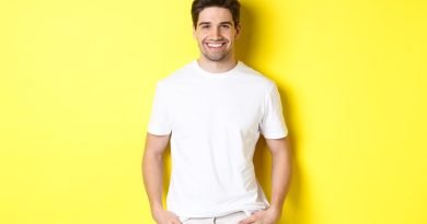 Homem usando um look All White. Ele está na frente de uma parede amarela