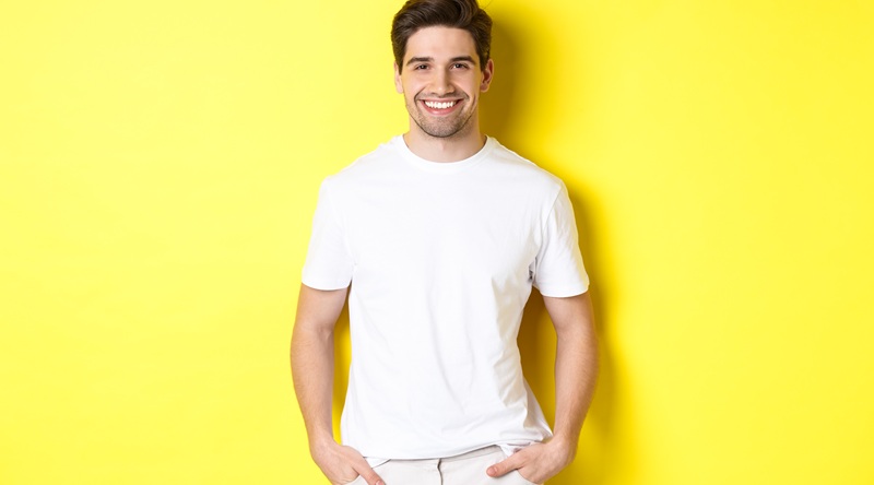 Look All White masculino: como acertar no Réveillon? 1 Homem usando um look All White. Ele está na frente de uma parede amarela