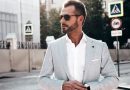Homem usando camisa branca e blazer cinza, além de óculos de sol e relógio de pulso