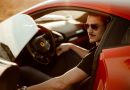 Homem de óculos escuros dentro de carro vermelho esportivo